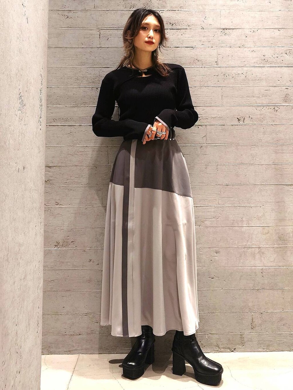 ブラック系のニット/セーター、ブラック系のショルダーバッグ、グレー系のスカートを着用したレディースの冬コーディネートの2枚目の写真