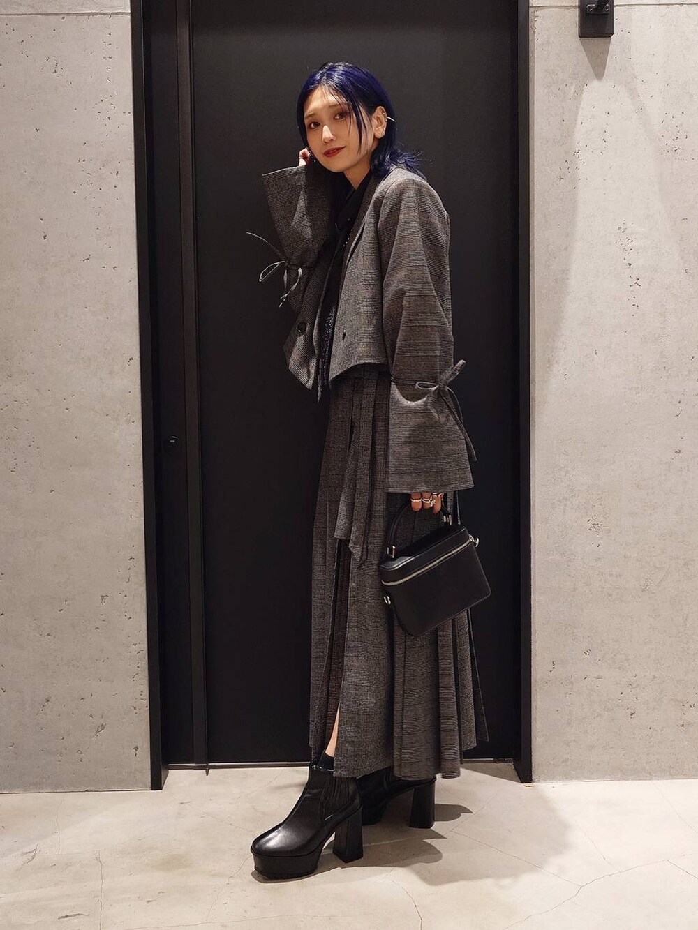 ブラック系のネクタイ、ブラック系のブーツ、ブラック系のショルダーバッグを着用したレディースの秋コーディネートの2枚目の写真