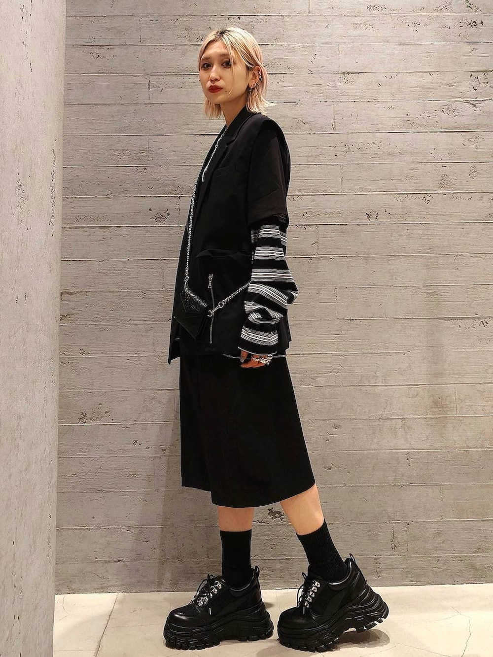 ブラック系のスニーカー、ブラック系のテーラードジャケット、ブラック系のスラックスを着用したレディースの春コーディネートの3枚目の写真