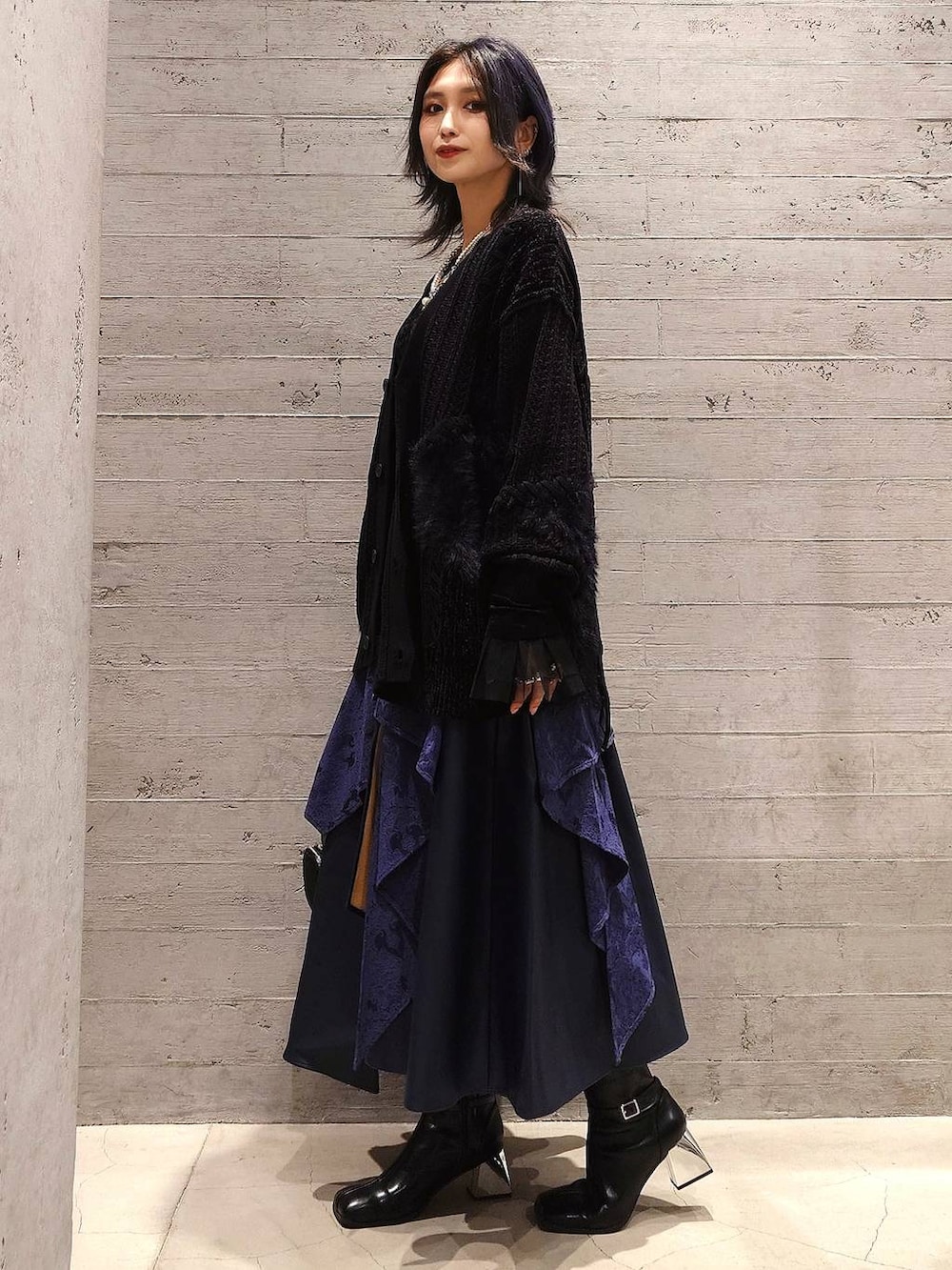 ブラック系のハンドバッグ、ブラック系のTシャツ/カットソー、ブラック系のブーツを着用したレディースの秋コーディネートの2枚目の写真
