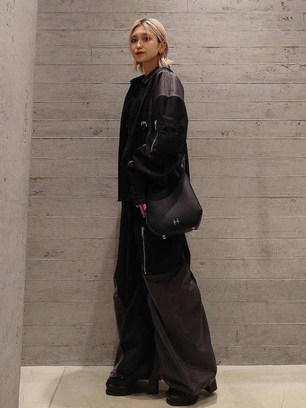 ブラック系のブーツ、ブラック系のショルダーバッグ、パープル系のTシャツ/カットソーを着用したレディースの春コーディネートの3枚目の写真