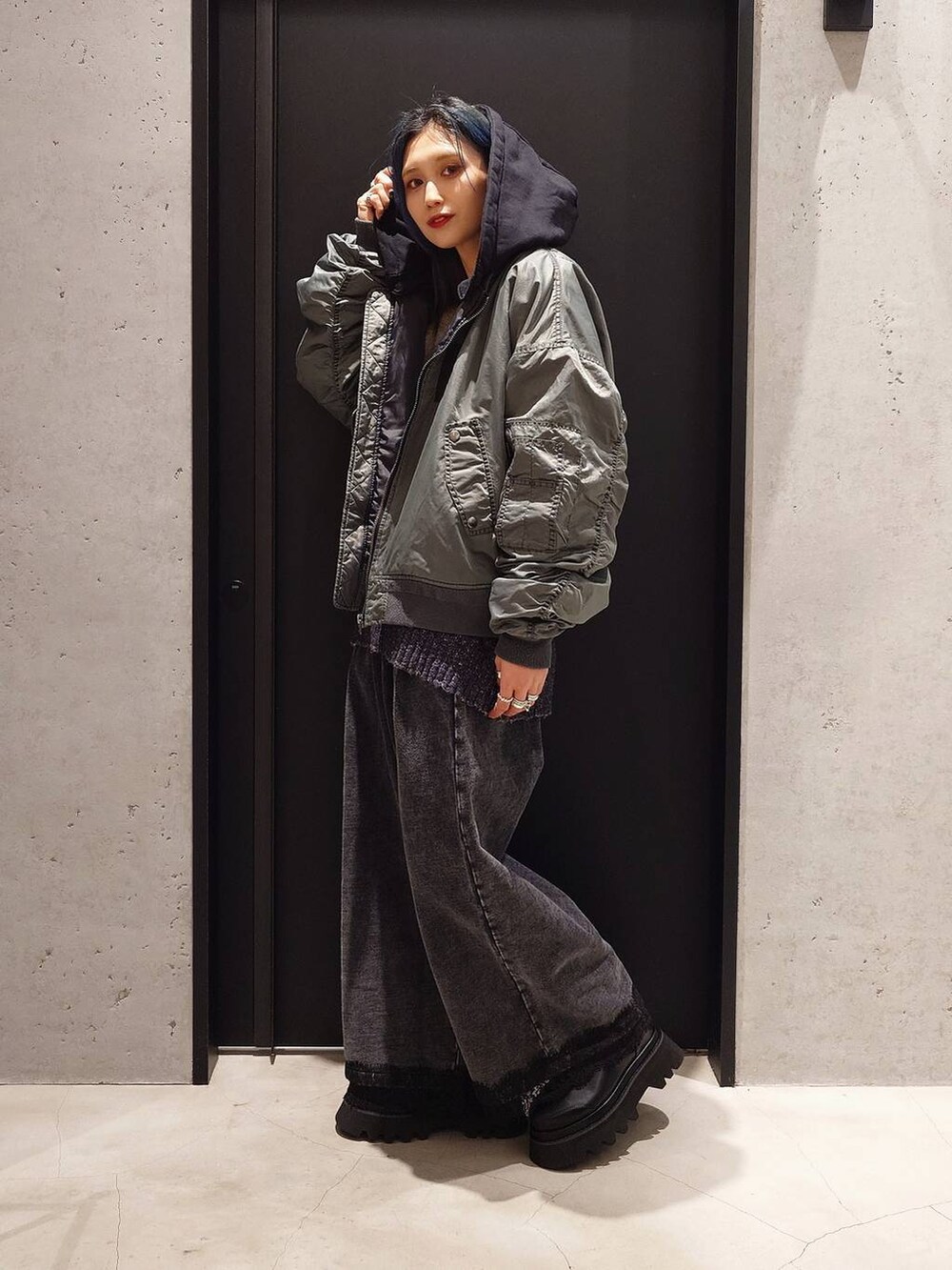 ブラック系のショルダーバッグ、ブラック系のスウェットパンツ、ブラック系のブーツを着用したレディースの冬コーディネートの3枚目の写真