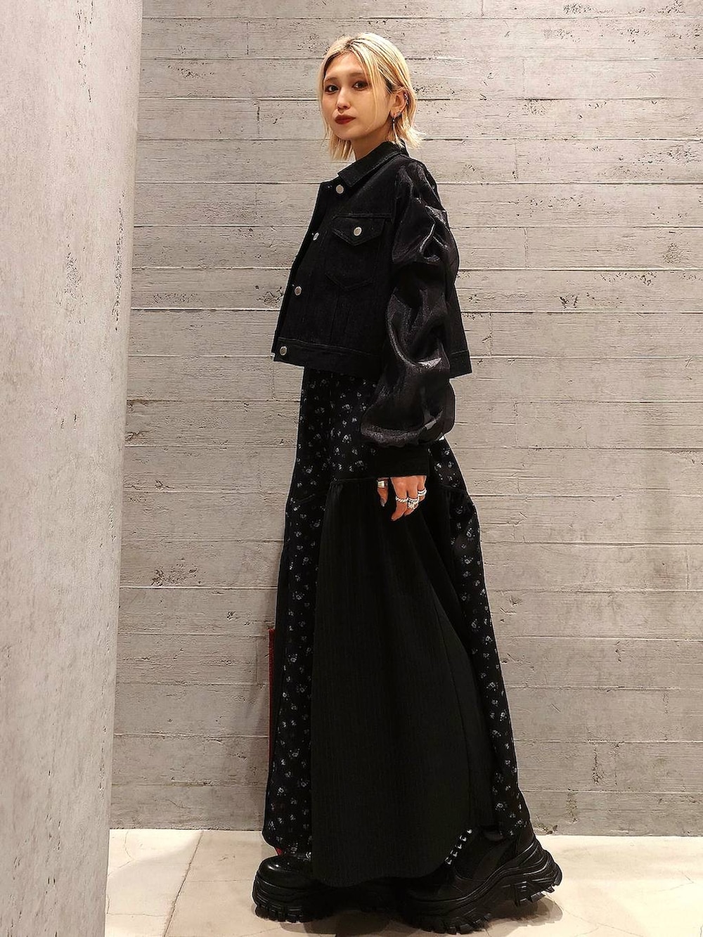 レッド系のトートバッグ、ブラック系のスニーカー、ブラック系のカーディガン/ボレロを着用したレディースの春コーディネートの3枚目の写真