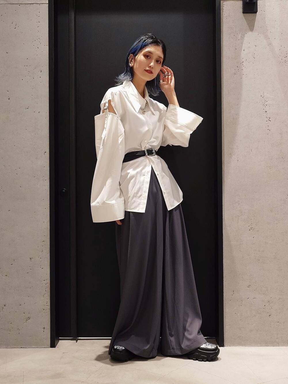 シルバー系のスニーカー、ブラック系のベスト、ホワイト系のシャツ/ブラウスを着用したレディースの夏コーディネートの2枚目の写真