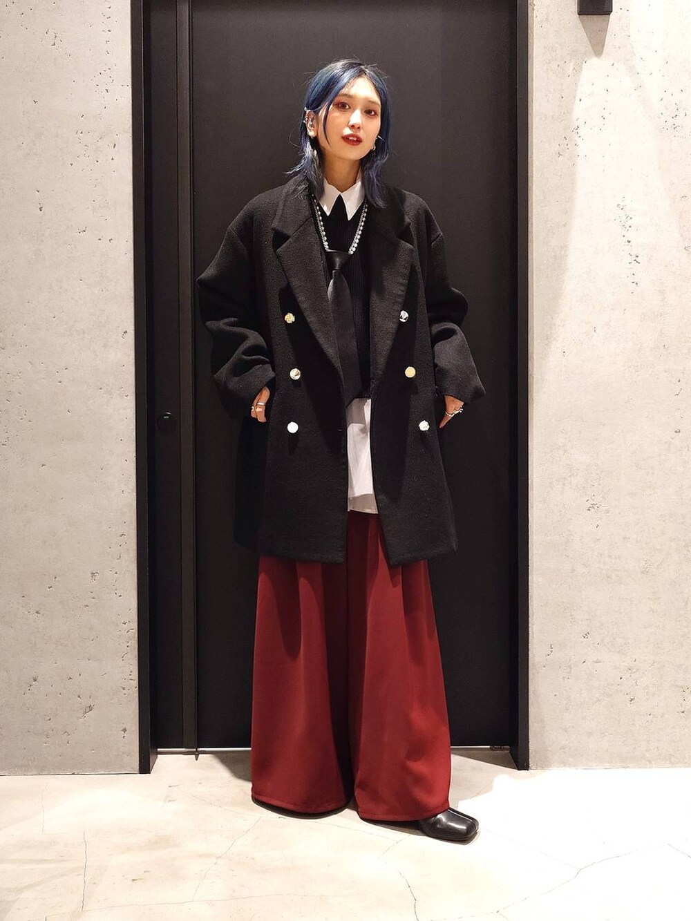 ブラック系のネクタイ、ブラック系のチェスターコート、ブラック系のブーツを着用したレディースの冬コーディネートの2枚目の写真