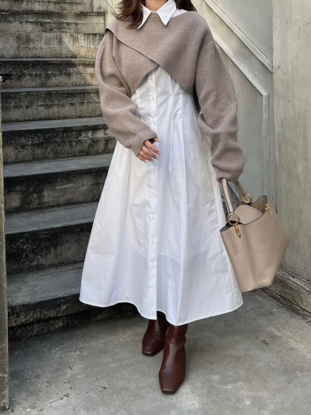 ブラウン系のブーツ、ベージュ系のバッグ、ホワイト系のシャツワンピースを着用したレディースの秋コーディネートの3枚目の写真