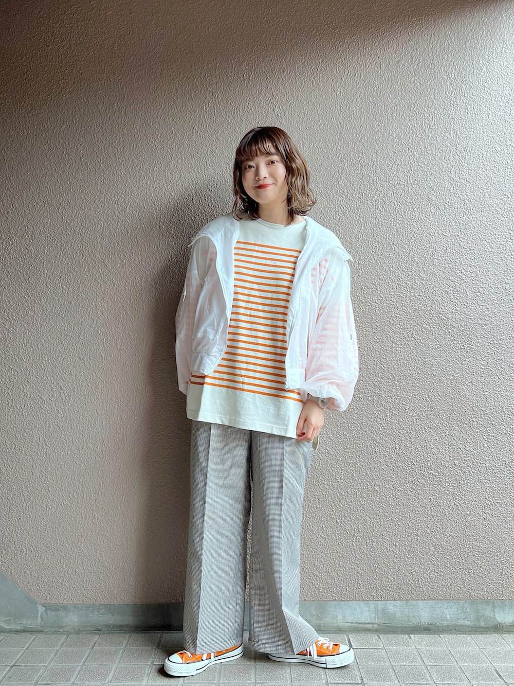 ホワイト系のナイロンジャケット、オレンジ系のTシャツ/カットソー、その他のセットアップを着用したレディースの春コーディネートの3枚目の写真