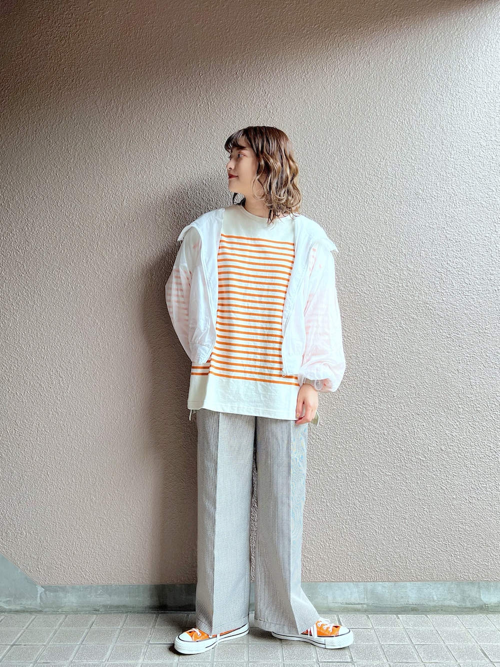 ホワイト系のナイロンジャケット、オレンジ系のTシャツ/カットソー、その他のセットアップを着用したレディースの春コーディネートの4枚目の写真