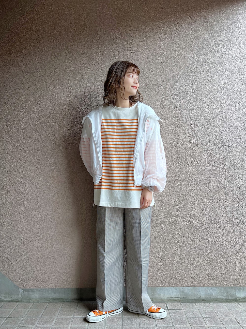 ホワイト系のナイロンジャケット、オレンジ系のTシャツ/カットソー、その他のセットアップを着用したレディースの春コーディネートの2枚目の写真