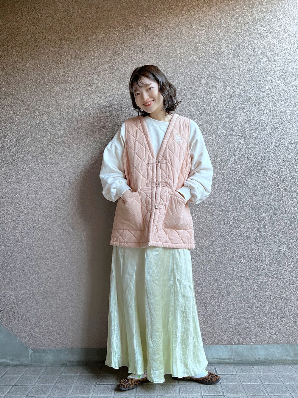 ピンク系のベスト、ベージュ系のスカートを着用したレディースの冬コーディネートの3枚目の写真