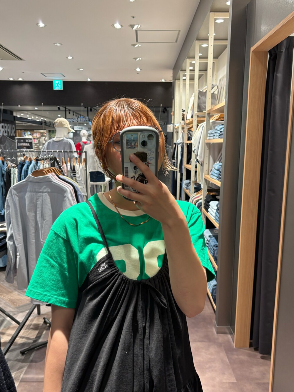 ブラック系のワンピース、ブラック系のデニムパンツ、グリーン系のTシャツ/カットソーを着用したレディースの夏コーディネートの2枚目の写真