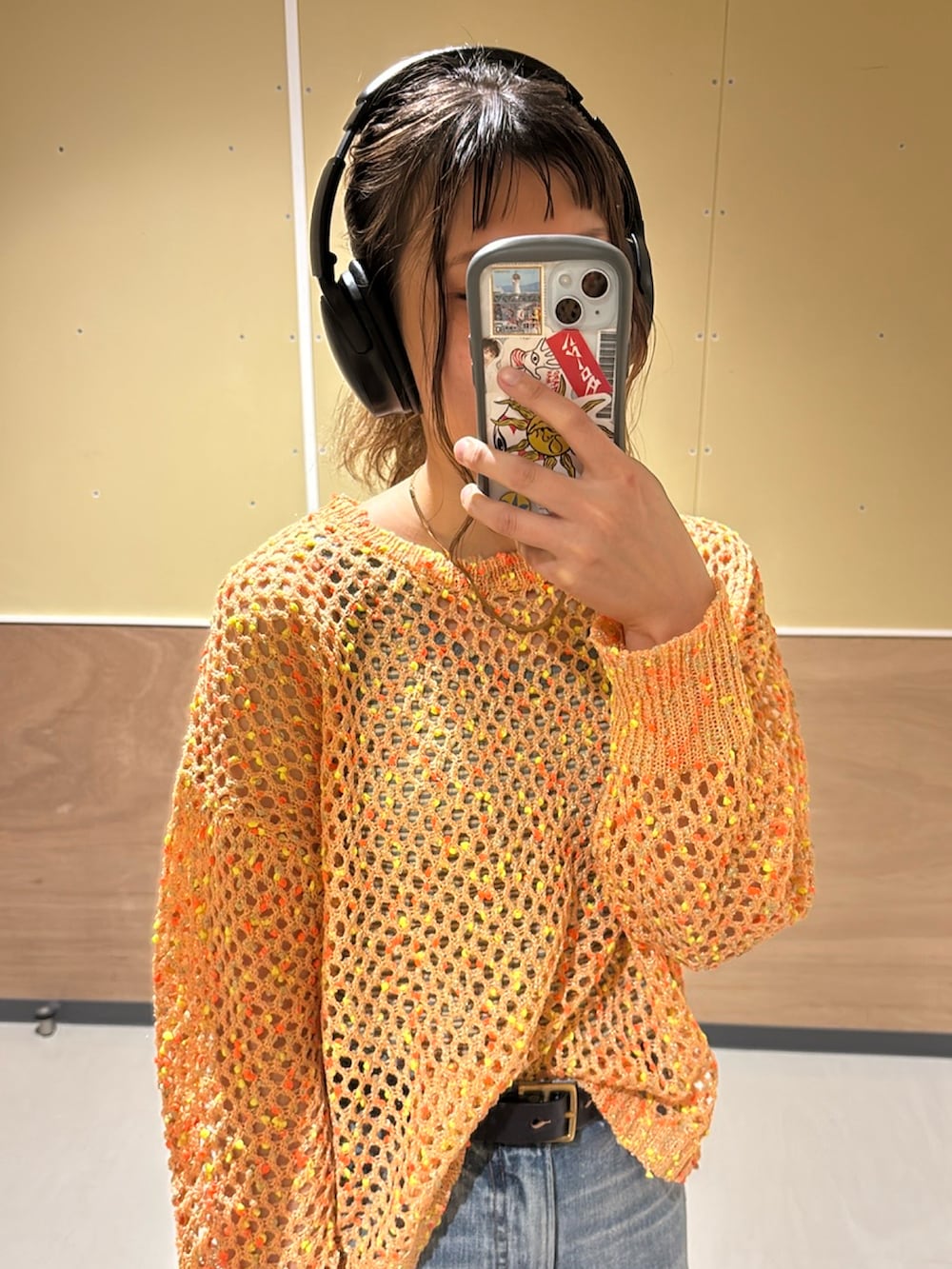 オレンジ系のニット/セーターを着用したレディースの春コーディネートの2枚目の写真