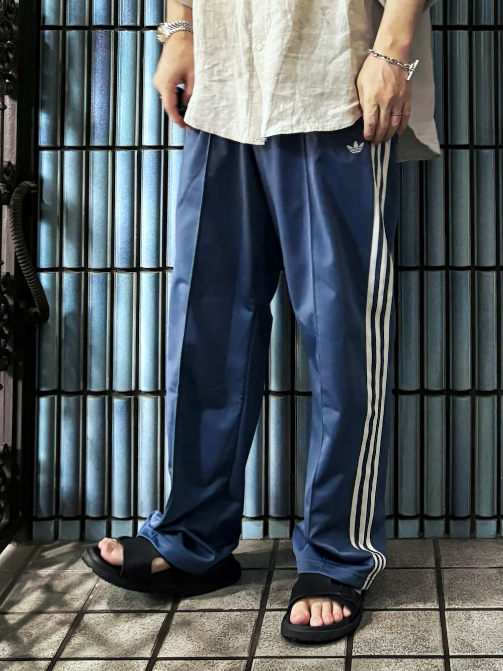 ベージュ系のシャツ/ブラウス、ブルー系のスウェットパンツ、ブラック系のサンダルを着用したメンズの夏コーディネートの3枚目の写真