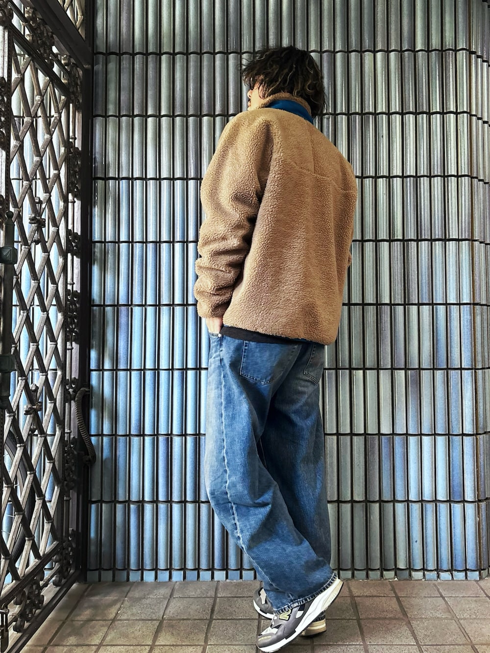 グレー系のスニーカー、グレー系のニット/セーター、ゴールド系のブルゾンを着用したメンズの冬コーディネートの4枚目の写真