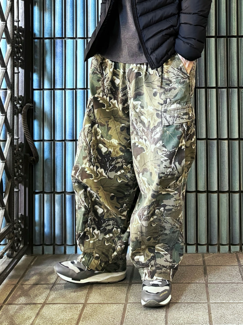 グリーン系のカーゴパンツ、グレー系のスニーカー、グレー系のTシャツ/カットソーを着用したメンズの冬コーディネートの3枚目の写真