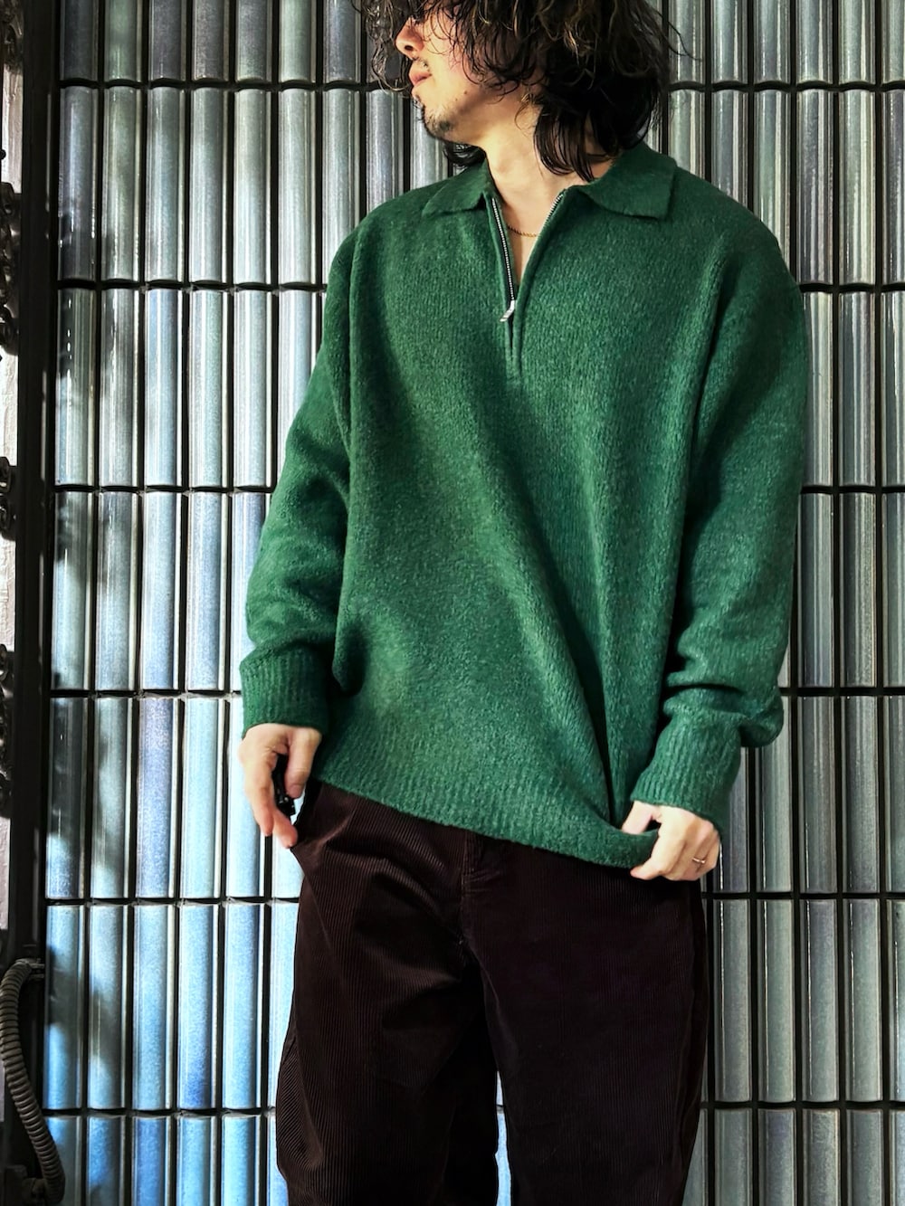 ブラック系のスニーカー、グリーン系のニット/セーター、ブラウン系のその他パンツを着用したメンズの冬コーディネートの2枚目の写真