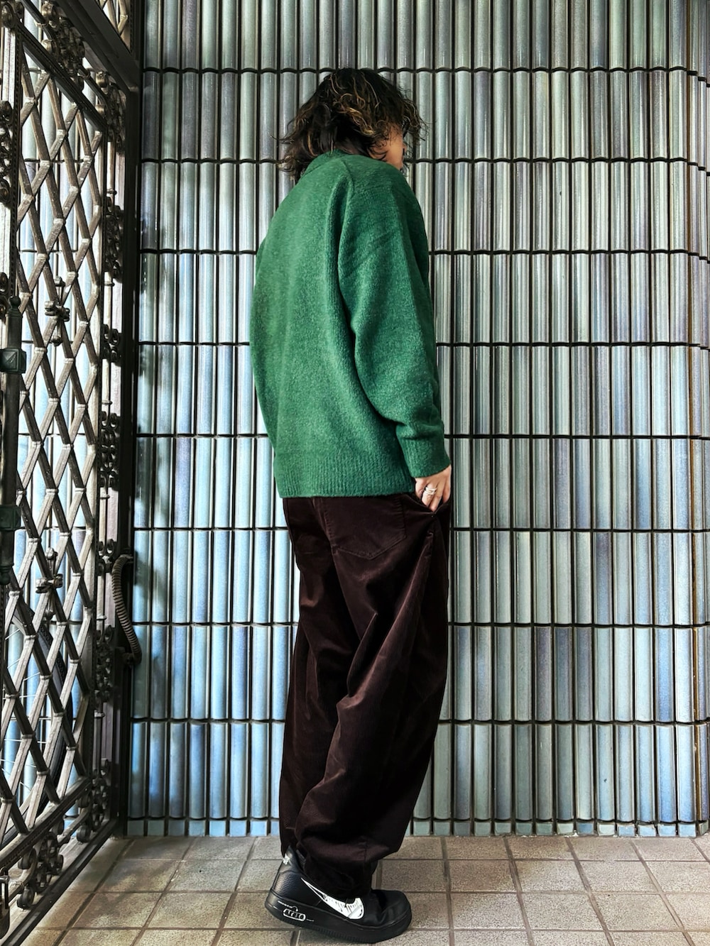 ブラック系のスニーカー、グリーン系のニット/セーター、ブラウン系のその他パンツを着用したメンズの冬コーディネートの4枚目の写真