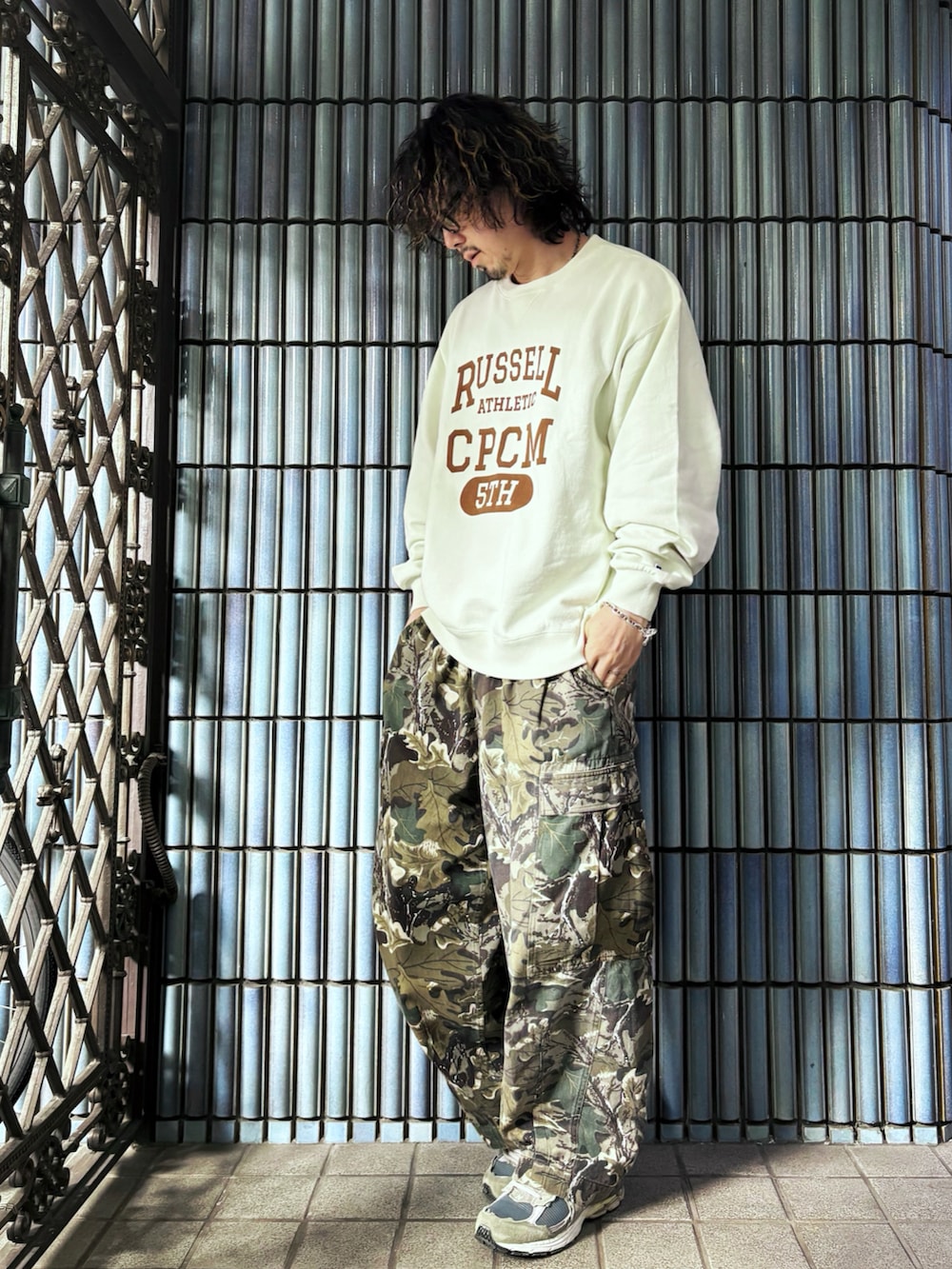 グリーン系のカーゴパンツ、ホワイト系のスウェット、グレー系のスニーカーを着用したメンズの春コーディネートの4枚目の写真