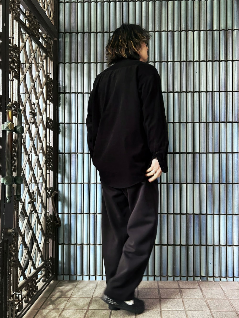 ブラウン系のニット/セーター、ブラック系のスニーカー、ブラック系のシャツ/ブラウスを着用したメンズの春コーディネートの4枚目の写真