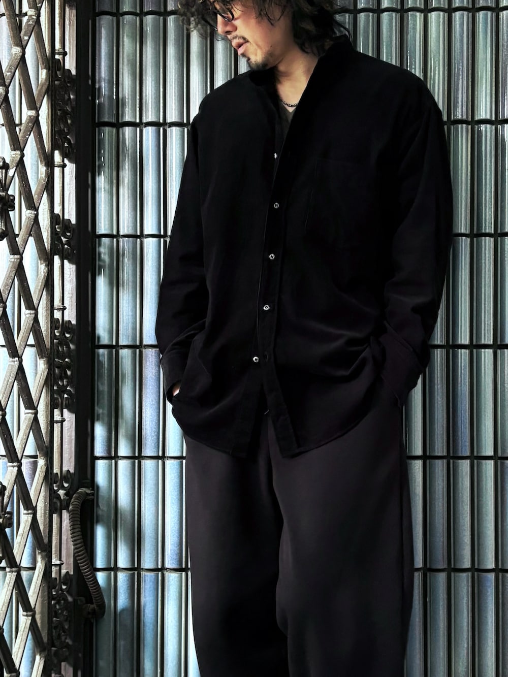 ブラウン系のニット/セーター、ブラック系のスニーカー、ブラック系のシャツ/ブラウスを着用したメンズの春コーディネートの2枚目の写真