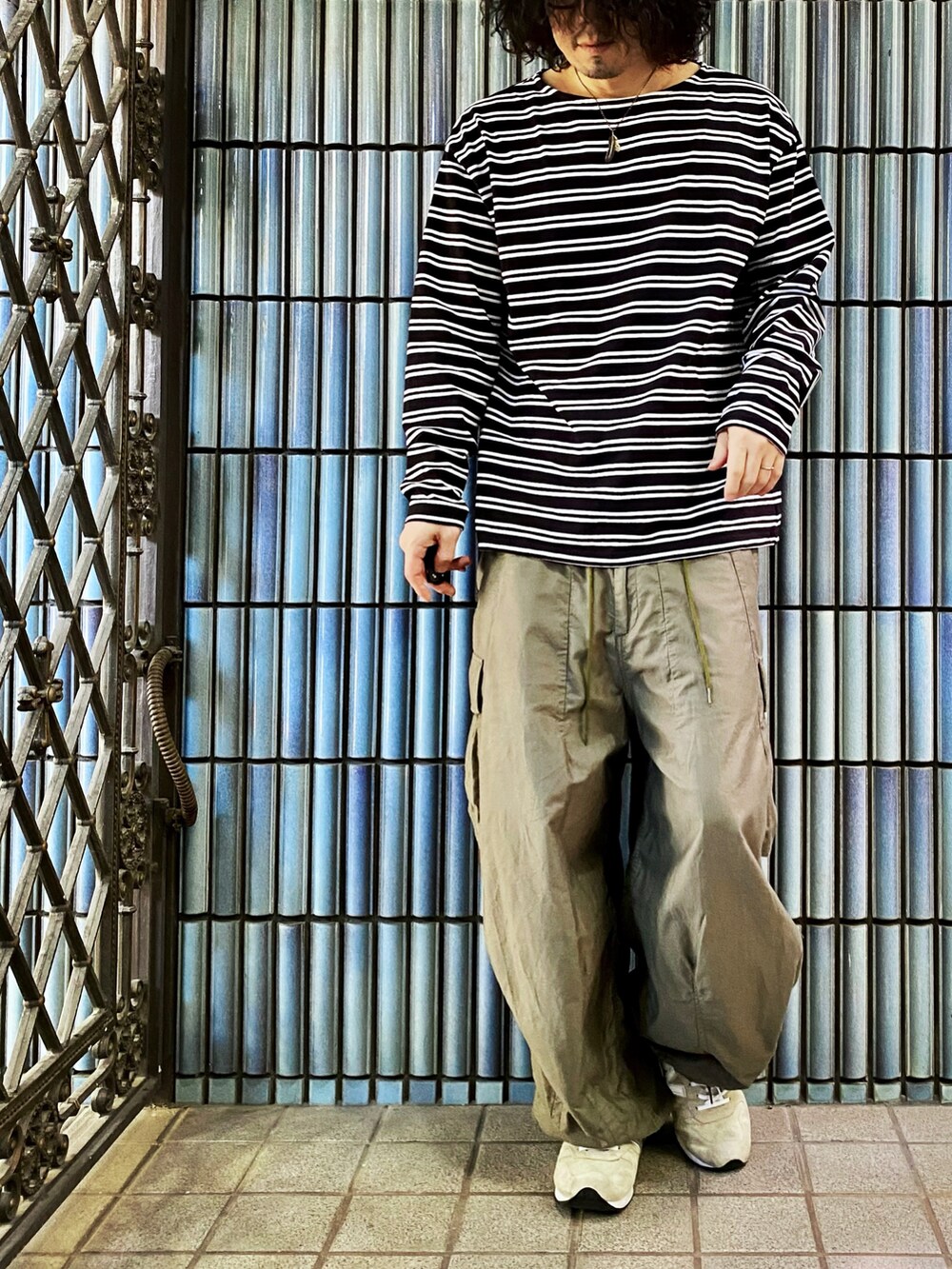 ブラック系のTシャツ/カットソー、グリーン系のカーゴパンツ、グレー系のスニーカーを着用したメンズの秋コーディネートの4枚目の写真