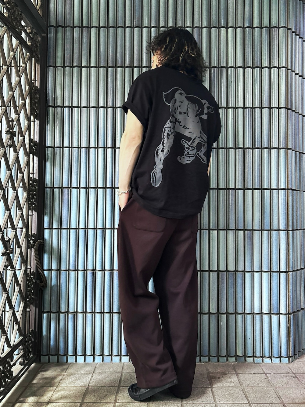ブラック系のTシャツ/カットソー、ブラウン系のスウェットパンツ、ブラック系のローファーを着用したメンズの春コーディネートの4枚目の写真