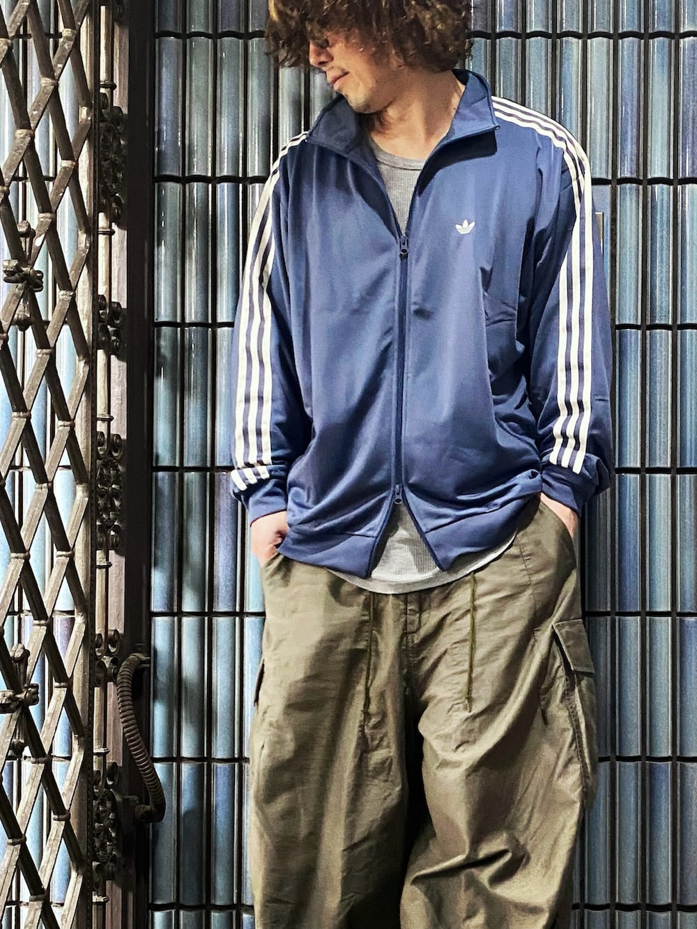 ブルー系のジャージ、グレー系のTシャツ/カットソー、グリーン系のカーゴパンツを着用したメンズの春コーディネートの2枚目の写真