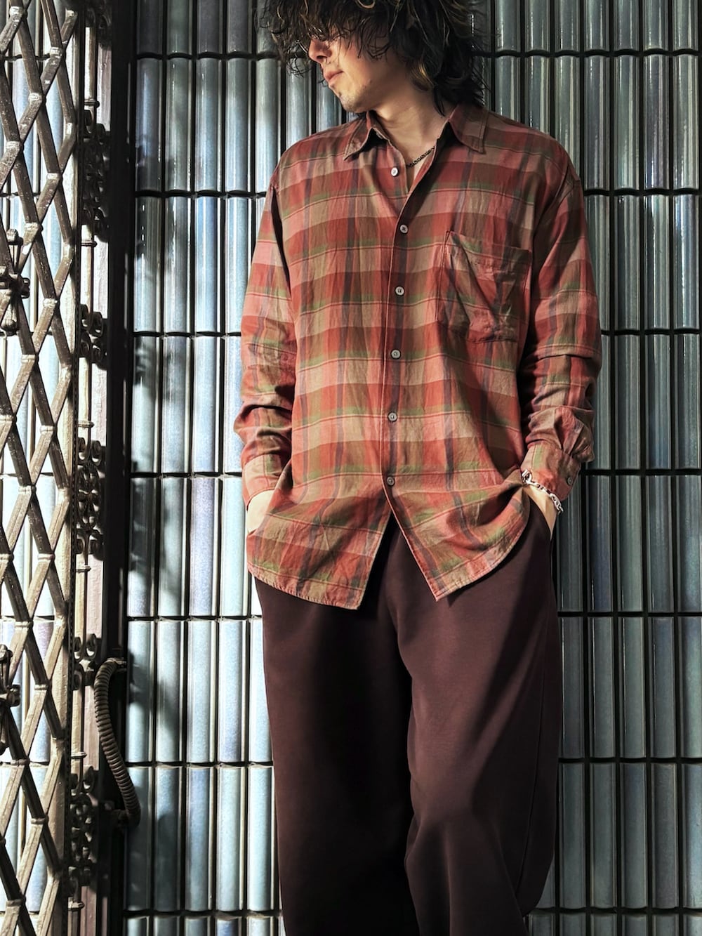 ブラック系のスニーカー、オレンジ系のシャツ/ブラウス、ブラウン系のスウェットパンツを着用したメンズの秋コーディネートの2枚目の写真