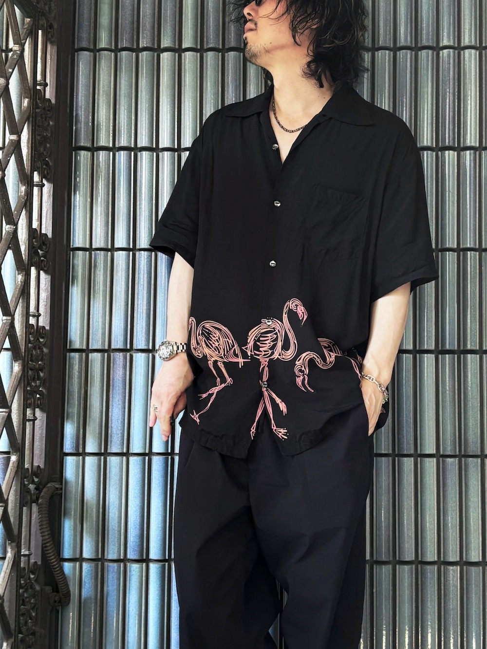 ブラック系のサンダル、ブラック系のシャツ/ブラウス、ブルー系のスラックスを着用したメンズの夏コーディネートの2枚目の写真