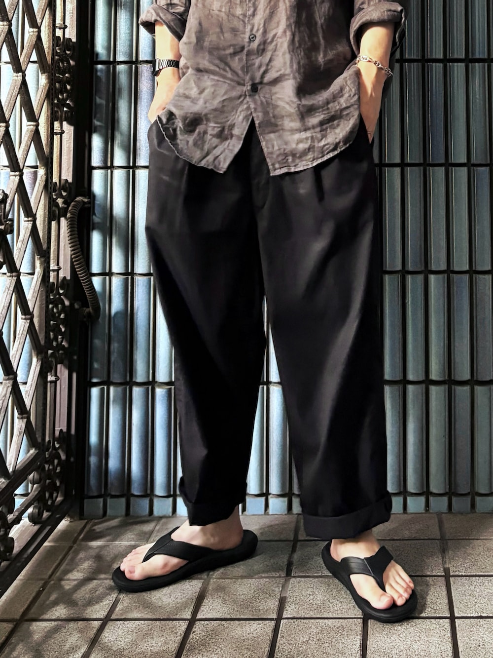 ブラック系のサンダル、ブラック系のその他パンツ、グレー系のシャツ/ブラウスを着用したメンズの秋コーディネートの3枚目の写真