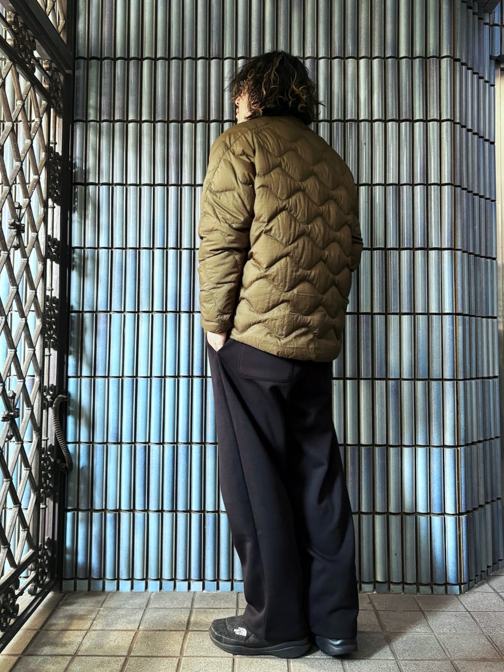 グリーン系のニット/セーター、グリーン系のダウンジャケット/コート、ブラック系のスウェットパンツを着用したメンズの冬コーディネートの4枚目の写真