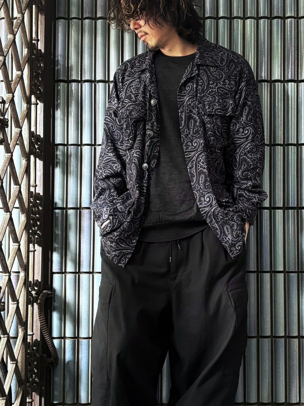 ブルー系のミリタリージャケット、ブラック系のカーゴパンツ、グレー系のニット/セーターを着用したメンズの冬コーディネートの2枚目の写真