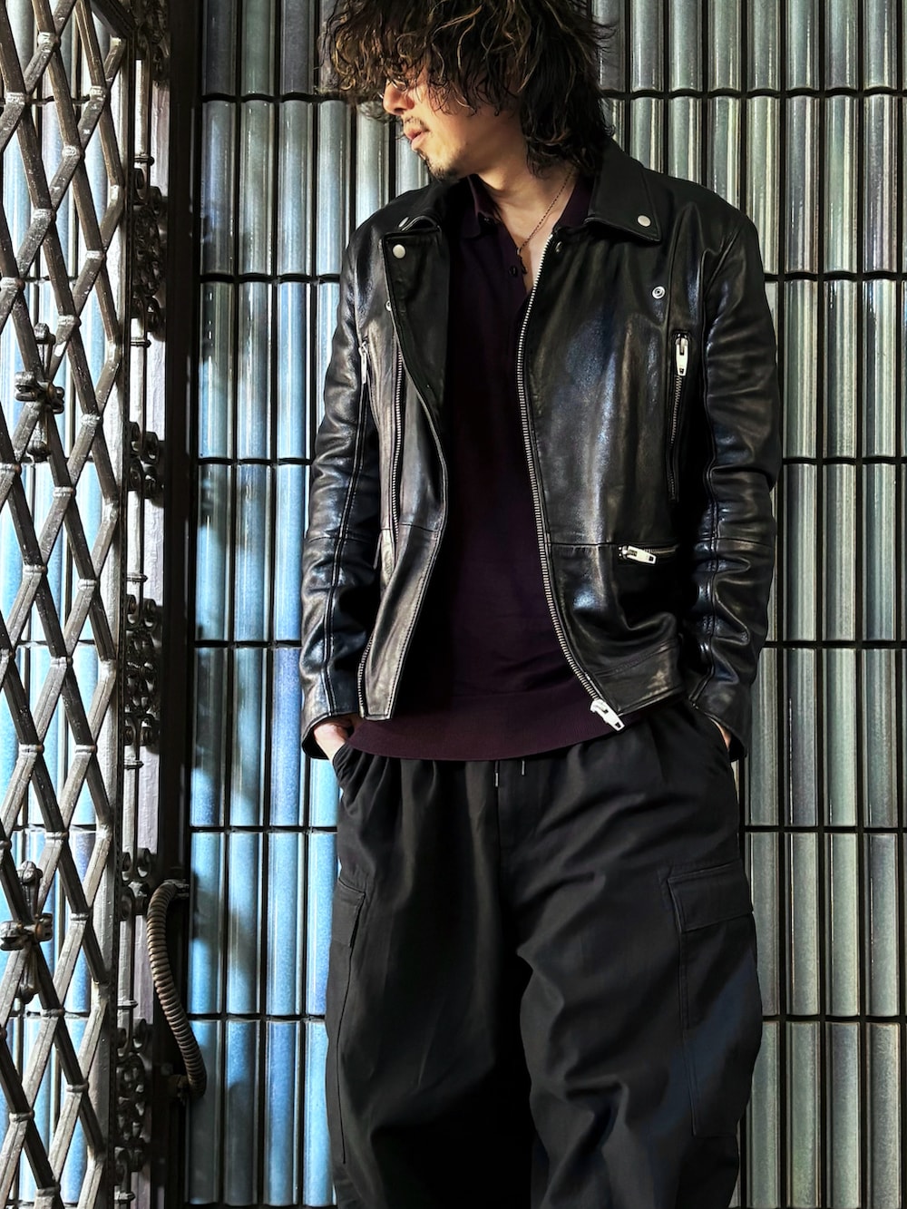 ブラック系のカーゴパンツ、ブラック系のスニーカー、パープル系のニット/セーターを着用したメンズの冬コーディネートの2枚目の写真