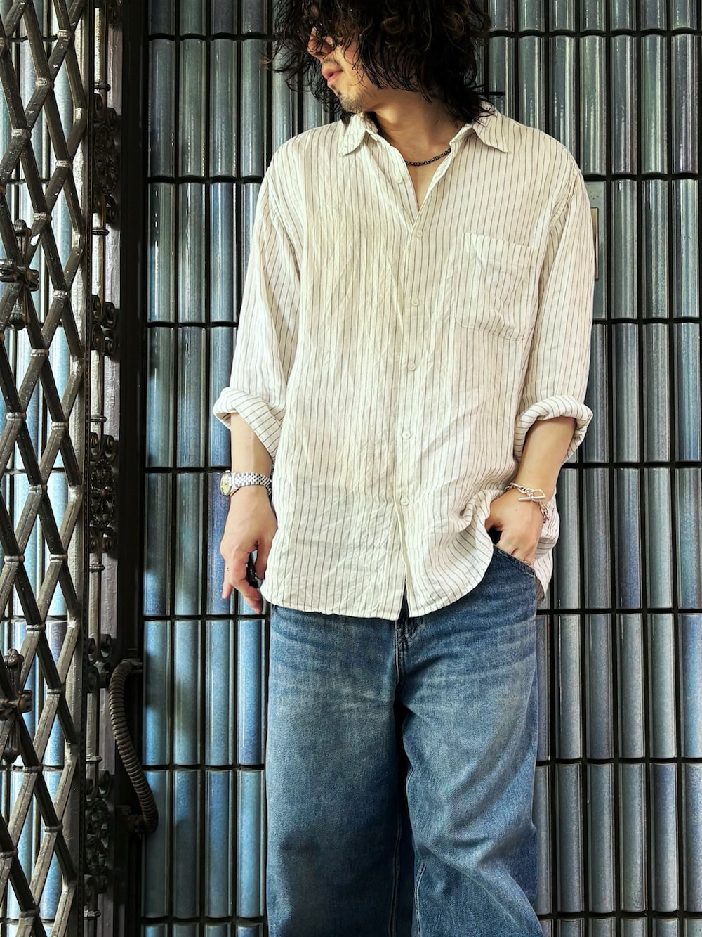 ブラウン系のサンダル、ホワイト系のシャツ/ブラウス、ブルー系のデニムパンツを着用したメンズの夏コーディネートの2枚目の写真