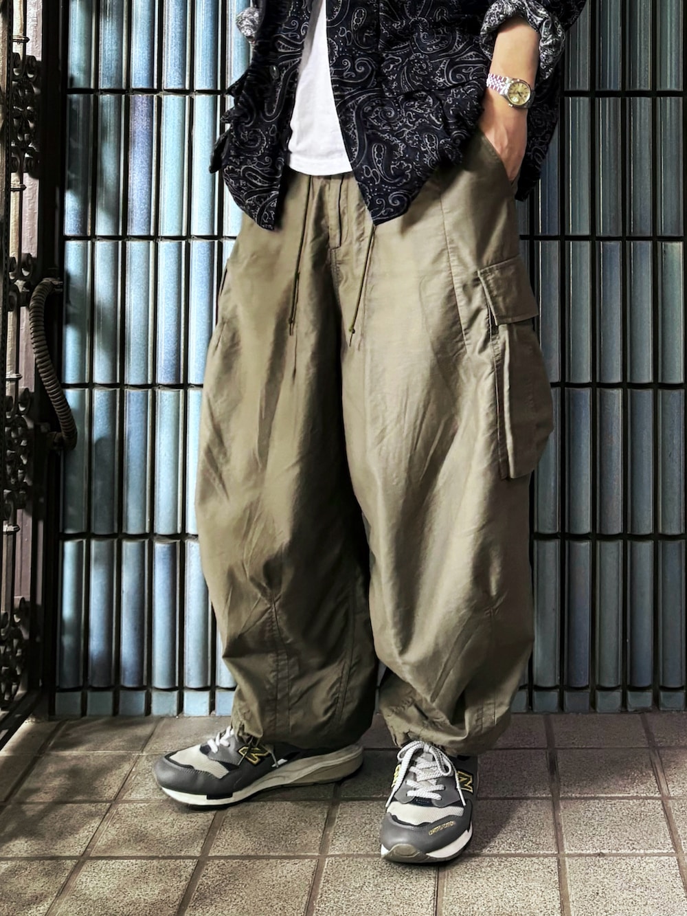 ブルー系のミリタリージャケット、ホワイト系のタンクトップ、グリーン系のカーゴパンツを着用したメンズの秋コーディネートの3枚目の写真