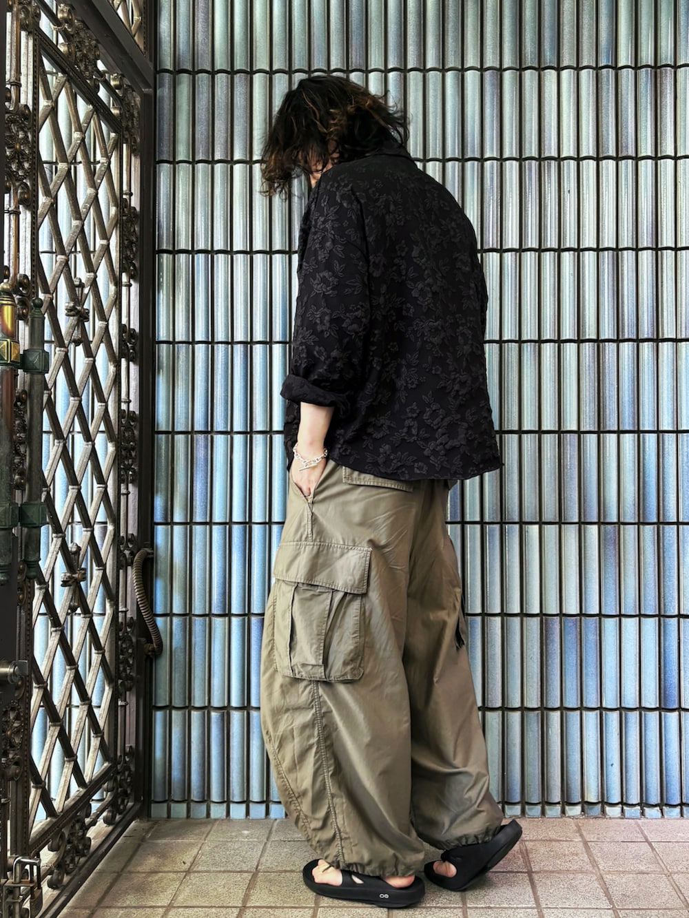 グリーン系のカーゴパンツ、ブラック系のサンダル、ブラック系のシャツ/ブラウスを着用したメンズの夏コーディネートの4枚目の写真