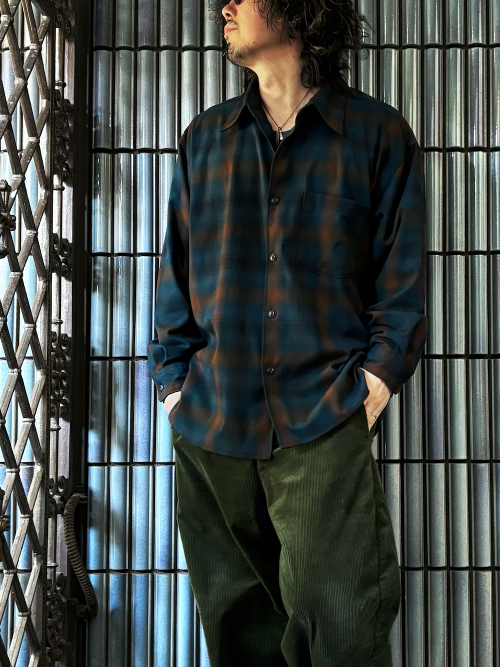 ブラック系のスニーカー、ブルー系のシャツ/ブラウス、グリーン系のその他パンツを着用したメンズの春コーディネートの2枚目の写真