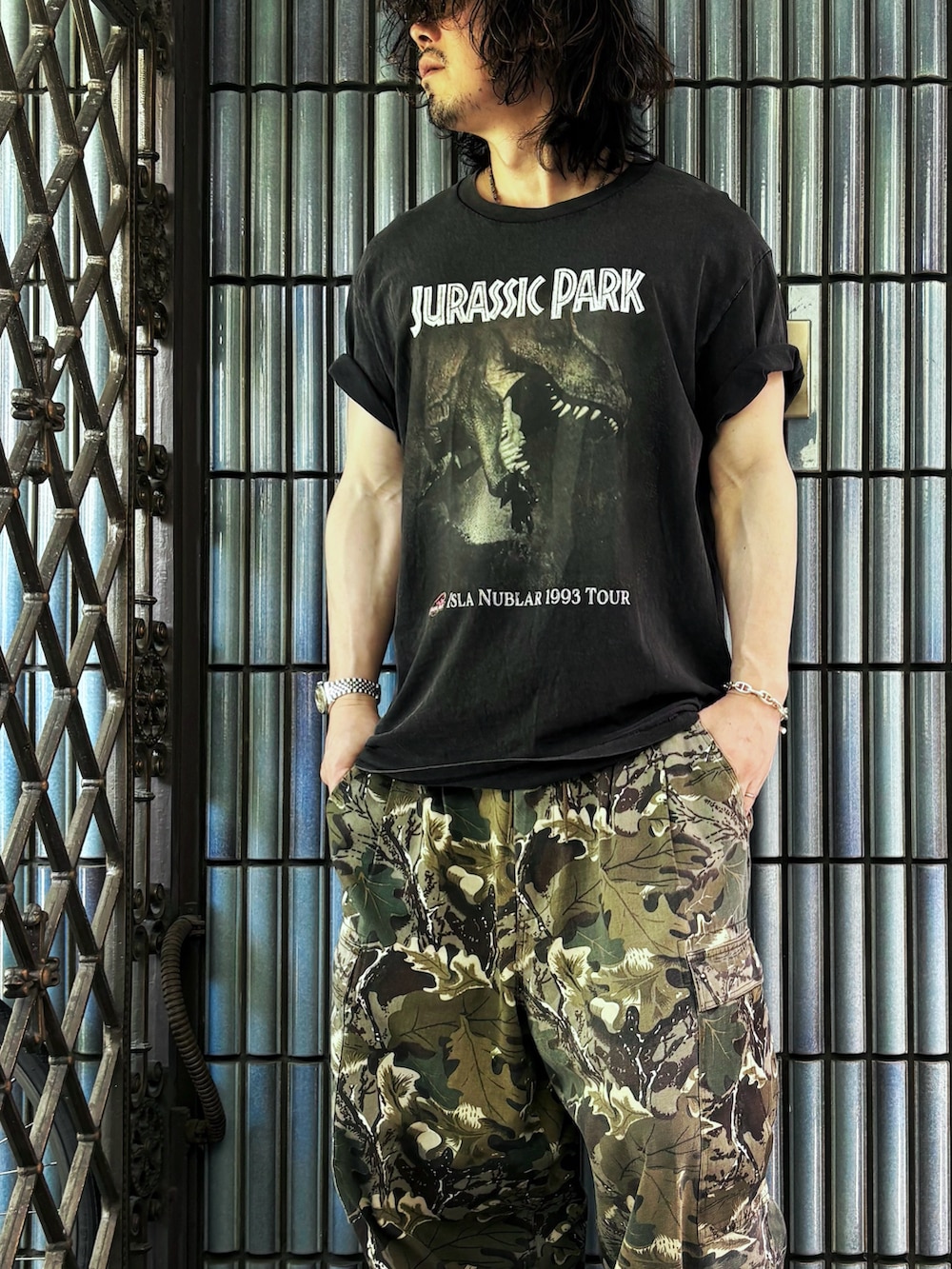 ブラウン系のサンダル、グリーン系のカーゴパンツ、ブラック系のTシャツ/カットソーを着用したメンズの夏コーディネートの2枚目の写真