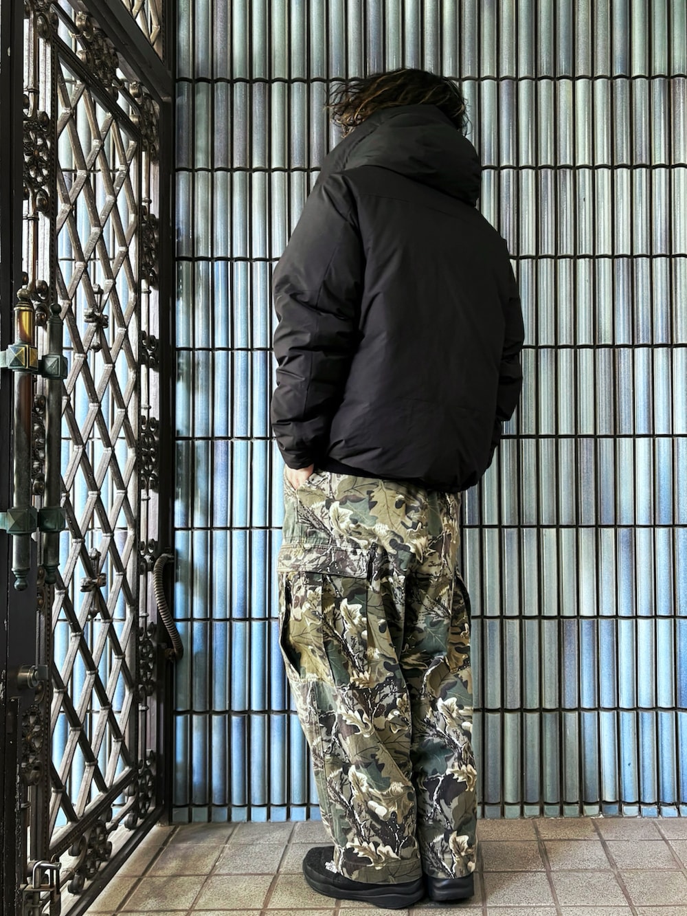 グリーン系のカーゴパンツ、ブラック系のダウンジャケット/コート、グレー系のブーツを着用したメンズの冬コーディネートの4枚目の写真