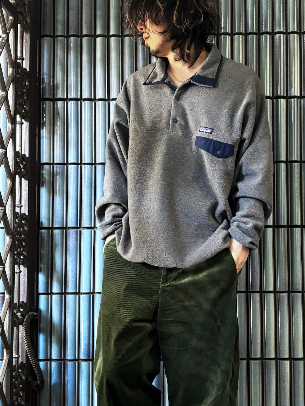 グレー系のニット/セーター、ブラック系のスニーカー、グリーン系のその他パンツを着用したメンズの冬コーディネートの2枚目の写真