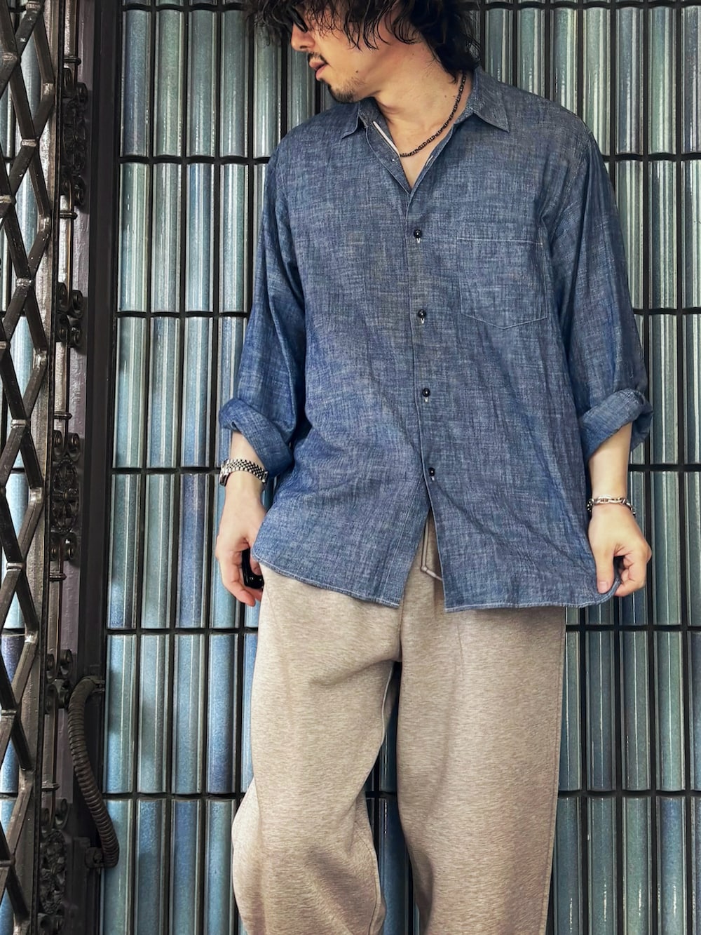 ブルー系のシャツ/ブラウス、ベージュ系のスウェットパンツ、ブラック系のローファーを着用したメンズの夏コーディネートの2枚目の写真