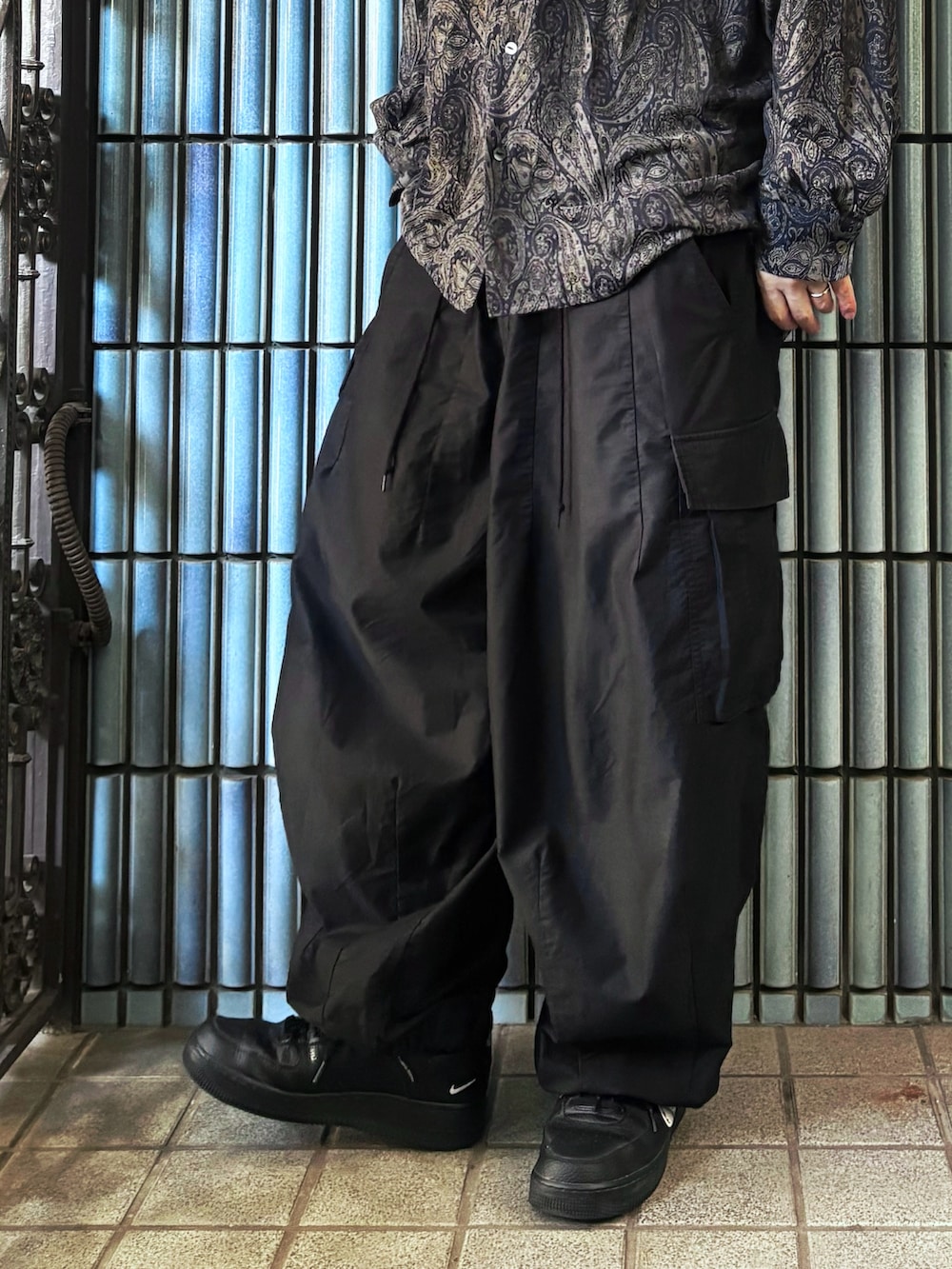 ブラック系のスニーカー、グレー系のシャツ/ブラウス、ブラック系のカーゴパンツを着用したメンズの秋コーディネートの3枚目の写真