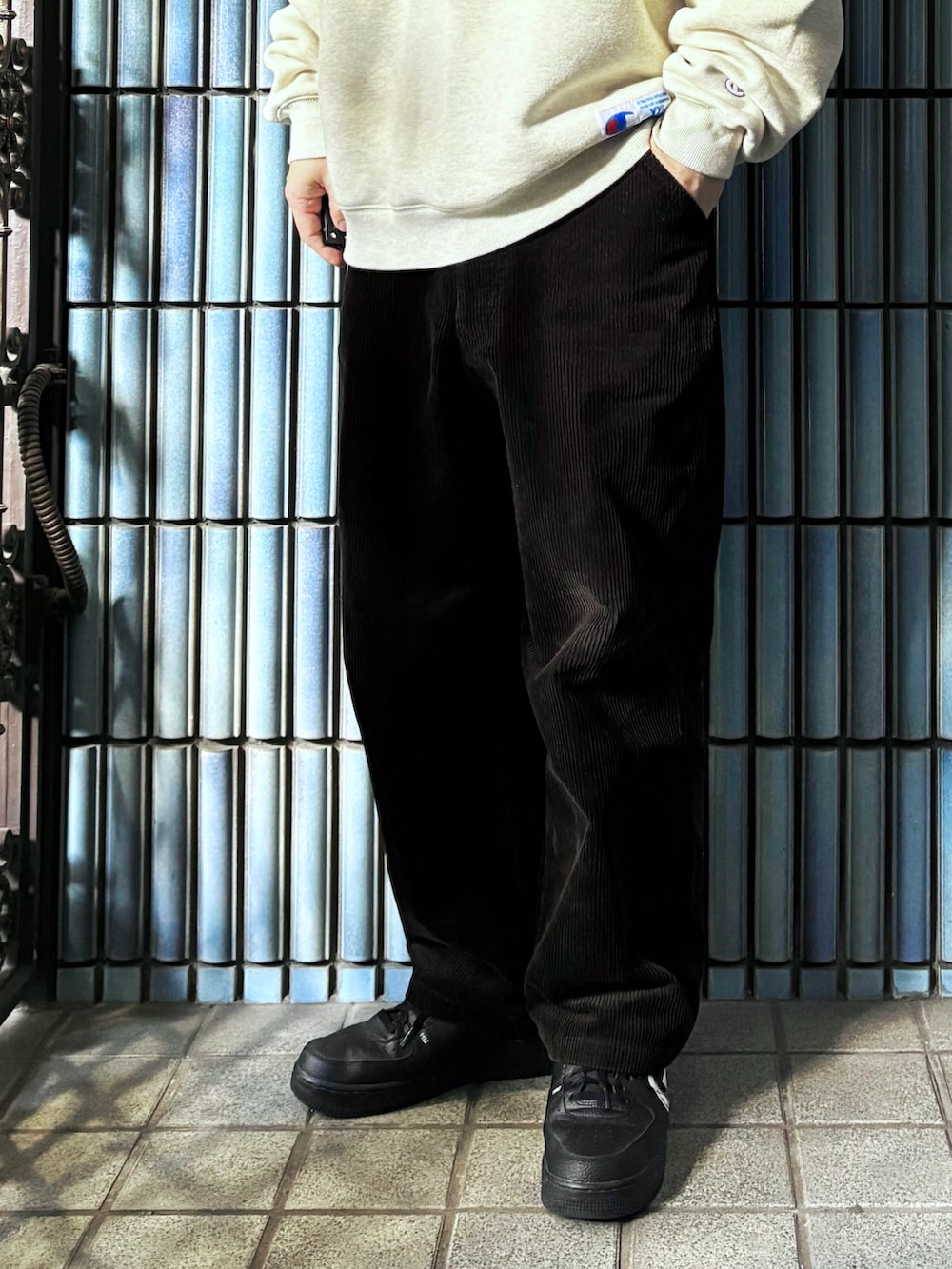 ベージュ系のスウェット、ブラック系のスニーカー、ブラウン系のその他パンツを着用したメンズの冬コーディネートの3枚目の写真