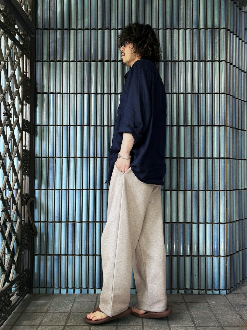ブラウン系のサンダル、ブルー系のシャツ/ブラウス、ベージュ系のスウェットパンツを着用したメンズの夏コーディネートの4枚目の写真