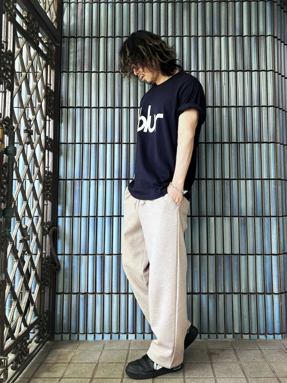 ブラック系のスニーカー、ブルー系のTシャツ/カットソー、ベージュ系のスウェットパンツを着用したメンズの春コーディネートの4枚目の写真