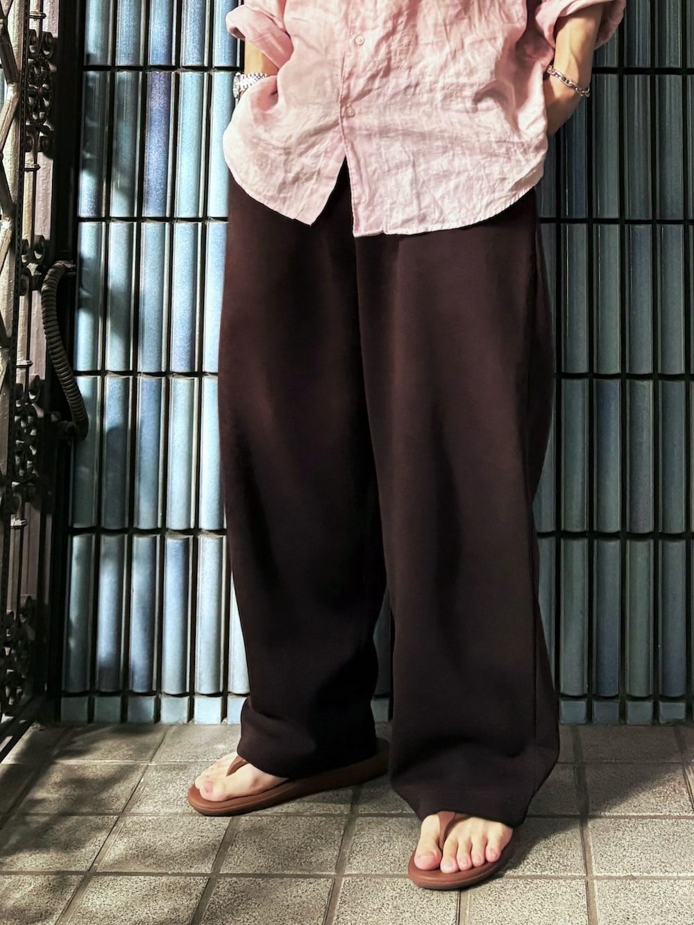 ブラウン系のサンダル、ピンク系のシャツ/ブラウス、ブラウン系のスウェットパンツを着用したメンズの秋コーディネートの3枚目の写真