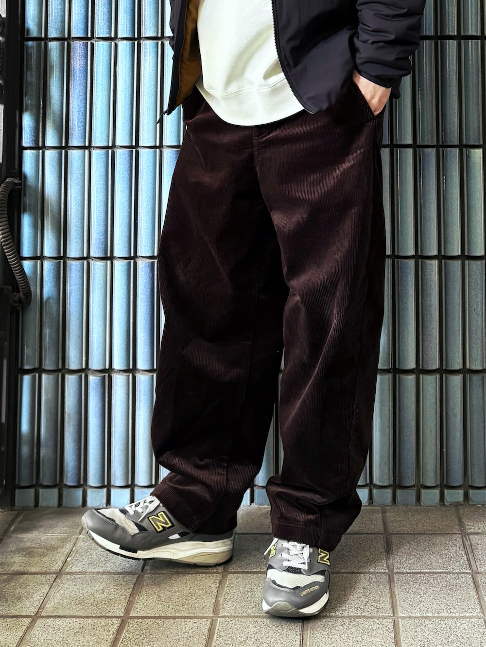 グレー系のスニーカー、ホワイト系のスウェット、ブラック系のダウンジャケット/コートを着用したメンズの冬コーディネートの3枚目の写真