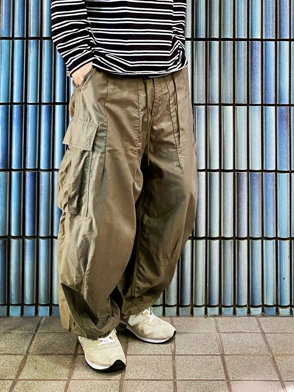 ブラック系のTシャツ/カットソー、グリーン系のカーゴパンツ、グレー系のスニーカーを着用したメンズの秋コーディネートの3枚目の写真