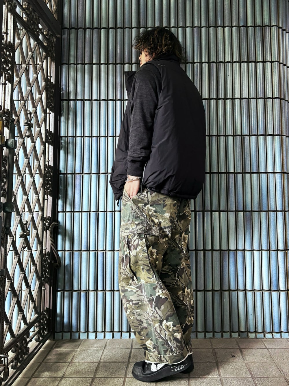 ブラック系のダウンベスト、グリーン系のカーゴパンツ、ブラック系のスニーカーを着用したメンズの冬コーディネートの4枚目の写真