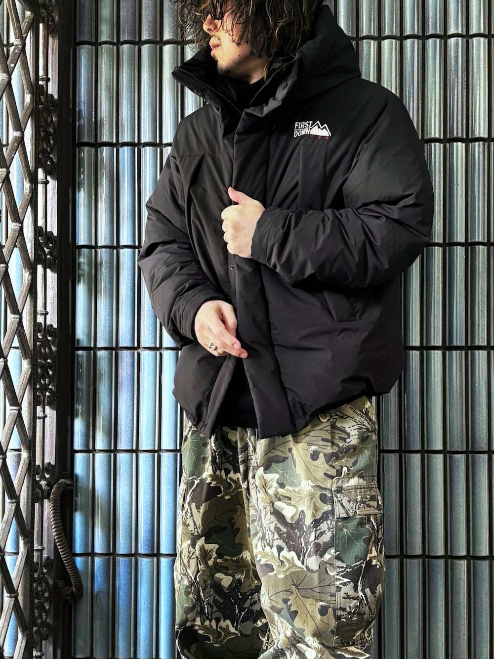 グリーン系のカーゴパンツ、ブラック系のダウンジャケット/コート、グレー系のブーツを着用したメンズの冬コーディネートの2枚目の写真